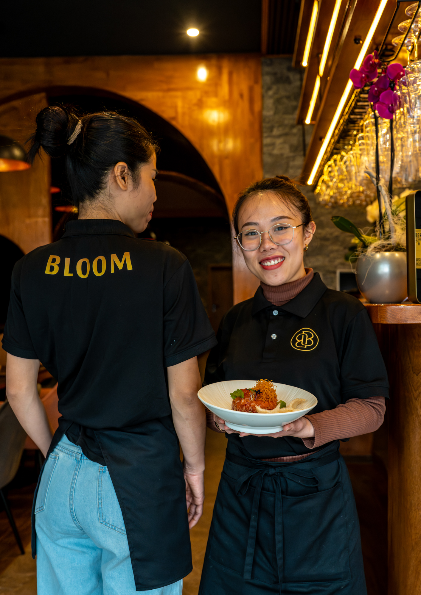 Das Bloom-Team serviert ein frisches asiatisches Gericht im stilvollen Restaurant